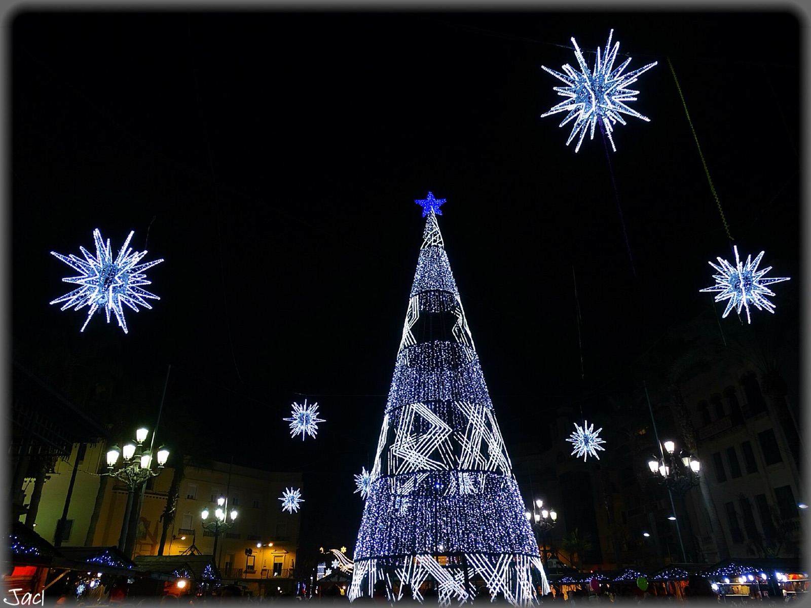 Árbol de Navidad luminoso y estrellas de luz en una plaza de Huelva