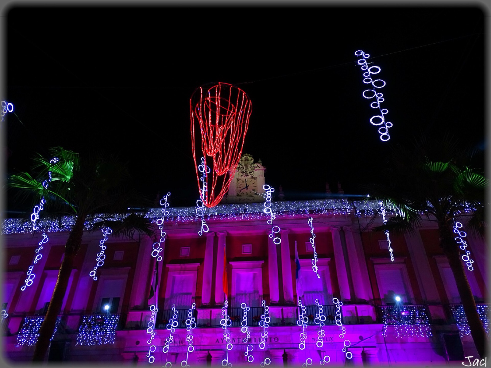 Fachada iluminada de morado y adornos de luz de Navidad en el centro de Huelva